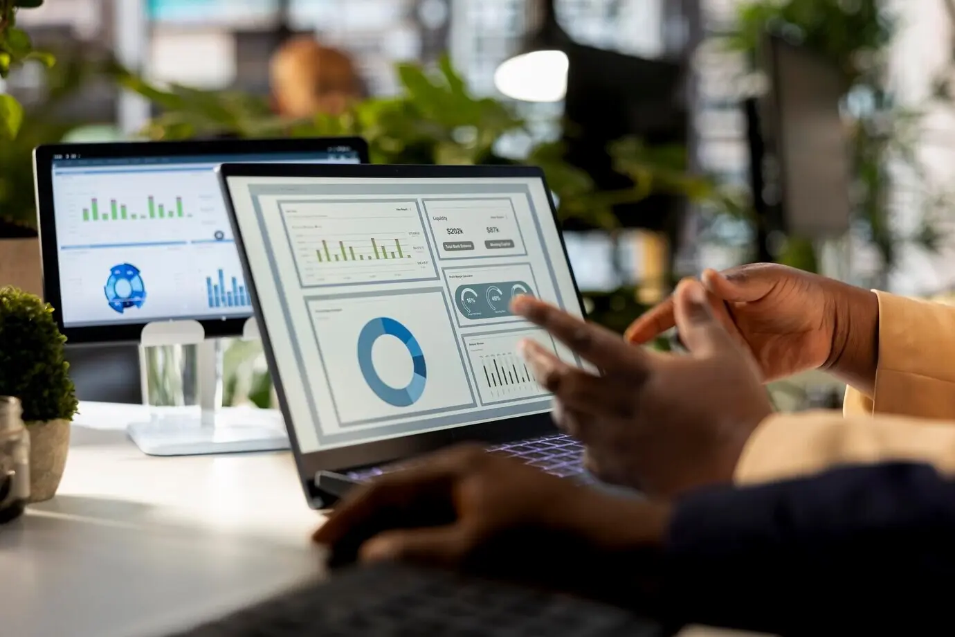 A business analyst meets with a colleague to review a financial report.
